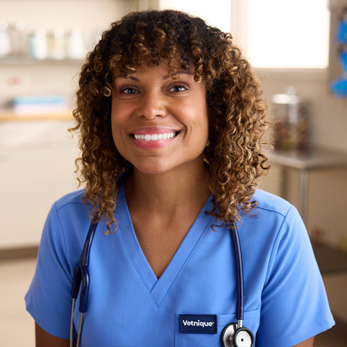 Dr. Joya Griffin in blue scrubs and a stethoscope, smiling in the vet office